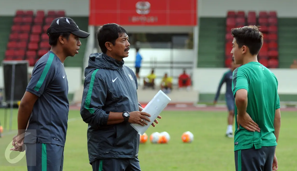 Pelatih Indra Sjafri (kiri) berbincang dengan Jack Brown saat latihan seleksi Timnas Indonesia U-19 di Lapangan Atang Sutresna, Jakarta, Kamis (6/4). 14 pemain yang pernah berlaga di luar negeri mengikuti seleksi masuk. (Liputan6.com/Helmi Fithriansyah)