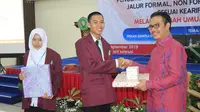 Kepala BKKBN, Hasto Wardoyo menyerahkan sebuah hadiah untuk mahasiswa STKIP Muhammadiyah Bangka Belitung karena berani bertanya pada saat Hasto mengisi kuliah umum di kampus tersebut pada Kamis malam, 12 September 2019 (Aditya Eka Prawira/Liputan6.com)