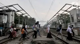 Warga menyeberangi perlintasan kereta di dekat Stasiun Buaran lama, Jakarta, Selasa (8/10/2019). Stasiun Buaran lama sudah tidak difungsikan sejak November 2018 akibat adanya Stasiun Buara baru. (merdeka.com/Iqbal Nugroho)