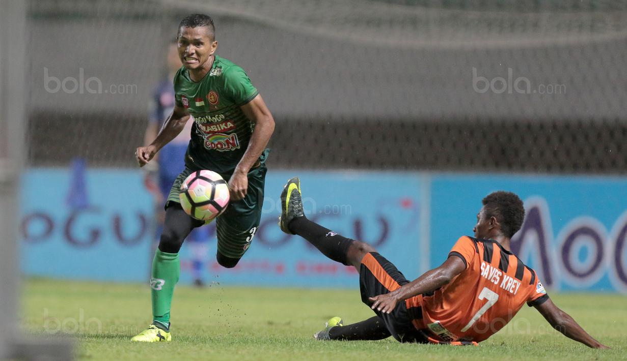 Pemain PS TNI, Abduh Lestaluhu (kiri) melewati adangan pemain Perseru Serui, Alba Serkadifat pada lanjutan Liga 1 2017 di Stadion Pakansari, Bogor (07/10/2017). PS TNI menang 2-1. (Bola.com/Nicklas Hanoatubun)