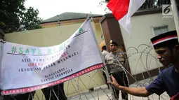 Massa Aliansi Anak Bangsa untuk Kemanusiaan memasang spanduk sebagai tanda penyegelan di depan Kedubes Myanmar, Jakarta, Selasa (5/9). Mereka menggelar aksi demonstrasi dan doa bersama dalam rangka bela Muslim Rohingya. (Liputan6.com/Faizal Fanani)