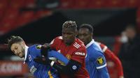 Gelandang Brighton and Hove Albion, Adam Lallana berebut bola dengan gelandang Manchester United, Paul Pogba pada pekan ke 30 Liga Inggris di Old Trafford, Senin dinihari WIB (05/04/2021). MU harus bekerja keras sebelum mengalahkan Brighton 2-1. (Phil Noble/Pool via AP)
