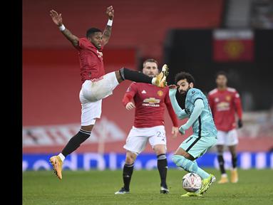 Pemain Manchester United, Fred (kiri) berusaha menghadang laju pemain Liverpool, Mohamed Salah pada laga babak keempat FA Cup 2020-21 di Old Trafford, Senin (25/01/2021). (Foto: AP/Pool/Laurence Griffiths)