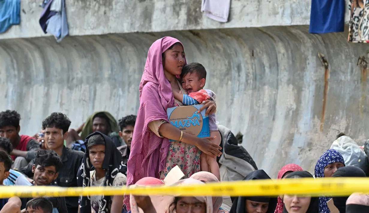 Pengungsi Rohingya yang baru tiba beristirahat di pesisir pantai di pulau Sabang, provinsi Aceh, Rabu (22/11/2023). (CHAIDEER MAHYUDDIN / AFP)