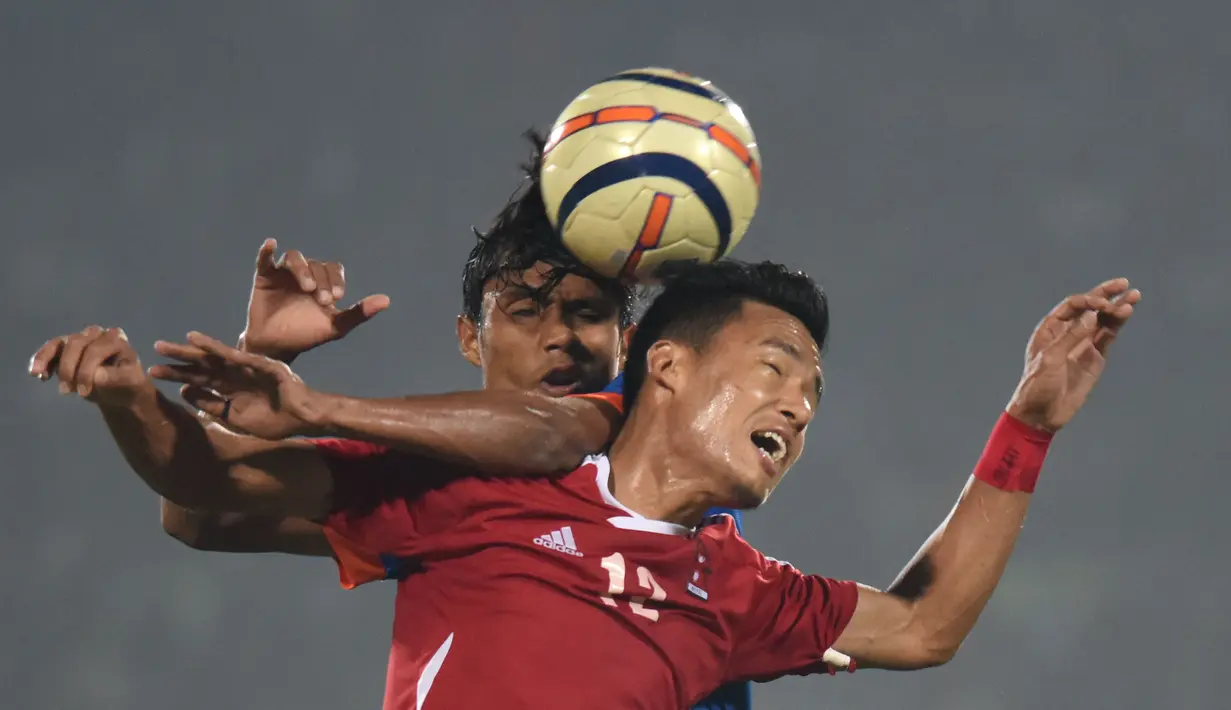 Pemain Nepal, Bikram Gurung (depan), berebut bola dengan pemain India dalam final sepak bola South Asian Games 2016 di Guwahati, India, (15/2/2016). (AFP/Biju Boro)