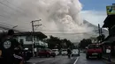 Pengendara melintasi jalanan ketika gunung Mayon mengeluarkan gumpalan asap raksasa di Camalig, selatan Manila, Senin (22/1). Filipina menaikkan Status Gunung Mayon menjadi level 4 setelah memuntahkan abu vulkanis setinggi 10 kilometer. (AFP PHOTO/STR)