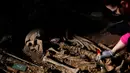 Arkeolog membersihkan salah satu kerangka manusi saat penggalian kuburan massal korban Perang Saudara Spanyol di El Carmen, Valladolid, (9/5). Menurut catatan sejarah Spanyol, lebih dari 100 ribu orang hilang dalam Perang Saudara. (REUTERS/Juan Medina)
