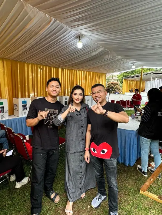 Ashanty tampil di Hari Pemilu bersama sang suami dan Azriel. Ashanty memamerkan jari kelingkingnya dengan outfit serba hitam; atasan berkerah lengan panjang dan rok panjang yang serasi. Sedangkan Anang dan Azriel kompak mengenakan kaus hitam bermotif dan celana panjang. [Foto: Instagram/azriel_hermansyah]