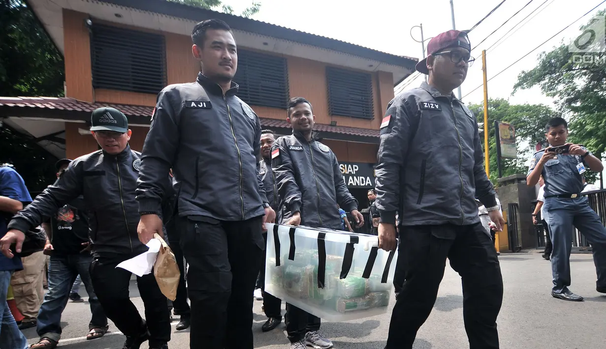 Tim Satuan Narkoba Jakbar membawa barang bukti sabu dan ekstasi saat rilis kasus narkoba di Mapolres Jakbar (26/11).  Polisi juga mengamankan 5 tersangka, 2 unit mobil, 6 buah kartu ATM, serta uang tunai sebesar Rp 3 juta. (Merdeka.com/Iqbal S. Nugroho)