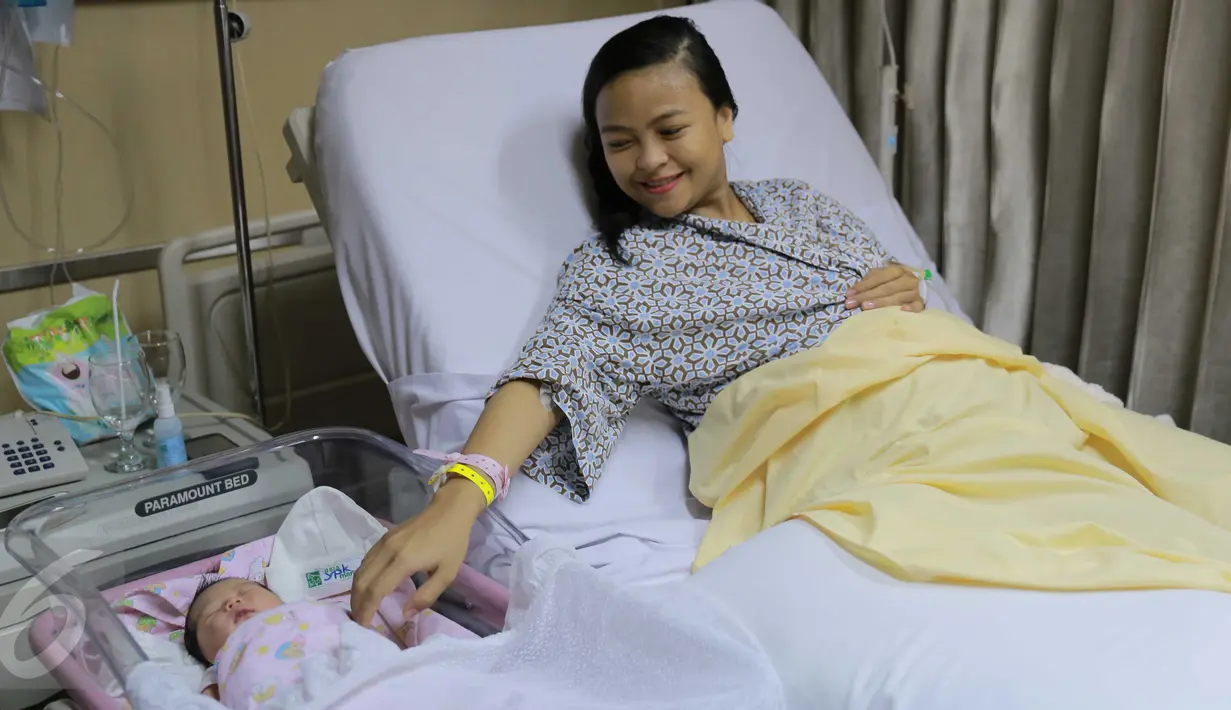 Vokalis Band Kotak Tantri Syalindri Ichlasari tampak ceria usai melahirkan di Rumah Sakit  YPK Mandiri, Jakarta, Minggu (24/4).Anak Tantri Kotak berjenis kelamin perempuan yang lahir pada sabtu (23/4) pukul 21.23 wib. (Liputan6.com/Gempur M Surya)