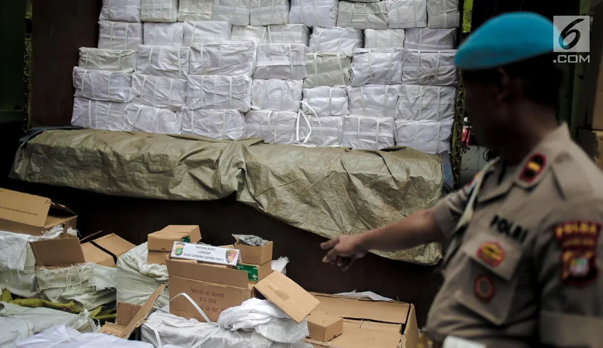 Petugas polisi menunjukkan barang bukti saat rilis kasus penyelundupan dan barang ilegal di Halaman Ditreskrimsus Polda Metro Jaya, Rabu (14/8/2019). Polisi mengamankan 11 truk berisi kosmetik, obat-obattan dan barang ilegal lainnya. (Liputan6.com/Faizal Fanani)