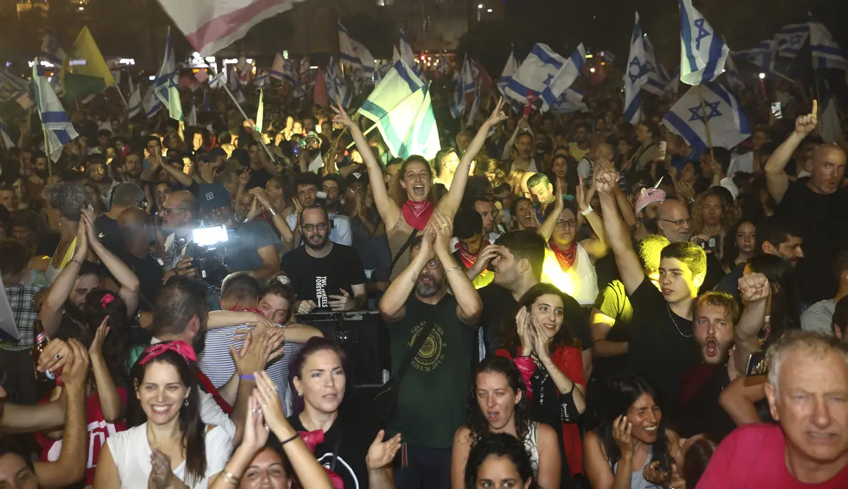 Warga Israel merayakan pelantikan pemerintahan baru di Tel Aviv, Israel, Minggu, 13 Juni 2021. Naftali Bennett, mantan sekutu Benjamin Netanyahu menjadi perdana menteri baru Israel. (AP Photo/Oded Balilty)