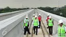 Menteri Perhubungan Budi Karya Sumadi mengecek pemasangan lintasan kereta dari atas lokasi LRT rute Cawang-Cibubur di tol Jagorawi Km 13, Jakarta, Minggu (8/1). Proyek LRT tahap 1 Cibubur-Cawang baru selesai 15 persen. (Liputan6.com/Helmi Afandi)