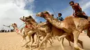 Joki cilik memacu tunggangan mereka selama Festival Balapan Unta Internasional di gurun Sarabium, Ismailia, Mesir, 12 Maret 2019. Sekitar 150 unta berkompetisi dalam delapan kategori jarak dari lima hingga 15 km.  (REUTERS/Amr Abdallah Dalsh)