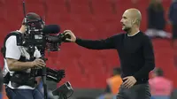 Pelatih Manchester City, Pep Guardiola menutup kamera usai timnya laga melawan Tottenham pada lanjutan Premier League di Wembley Stadium, (14/4/2018). Manchester City menang 3-1. (AP/Tim Ireland)