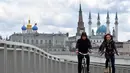 Pesepeda melintas di atas jembatan sungai Kazanka dengan latar belakang masjid Kul-Sharif di Kazan, Rusia, 9 Juni 2018. Masjid yang selalu ramai ini tidak hanya sebagai tempat ibadah, namun juga sebagai museum dan Islamic Center. (AFP PHOTO/SAEED KHAN)