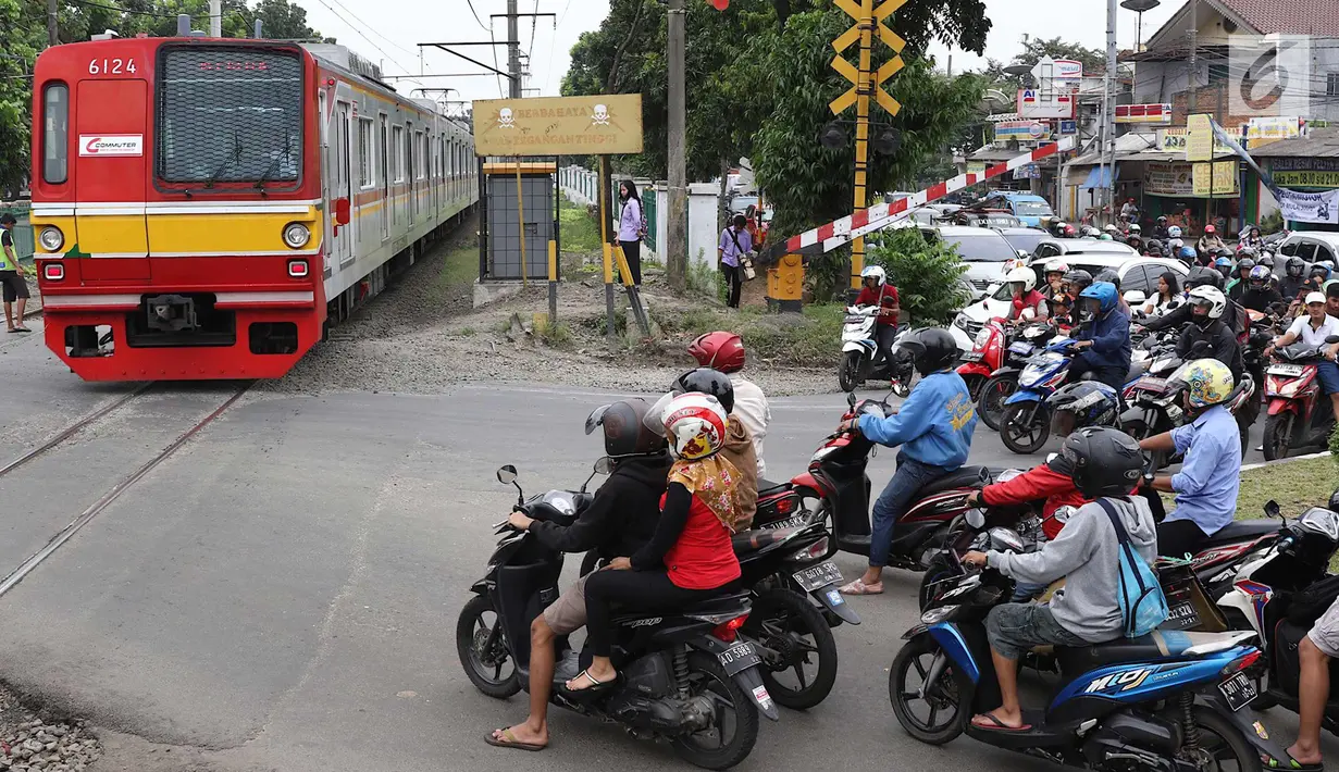 Kereta melintas di kawasan Lenteng Agung, Jakarta, Selasa (13/3). Untuk mengurai kemacetan imbas antrian kendaraan berputar balik di pintu kereta IISIP, Pemprov DKI berencana membangun flyover U-Turn di kawasan tersebut. (Liputan6.com/Immanuel Antonius)
