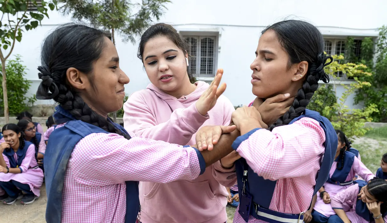 Juara karate internasional Muslim India, Syeda Falak mengajari teknik bela diri kepada dua siswi di Telangana Minorities Residential Girls School di Hyderabad, India (17/6). (AFP Photo/Noah Seelam)