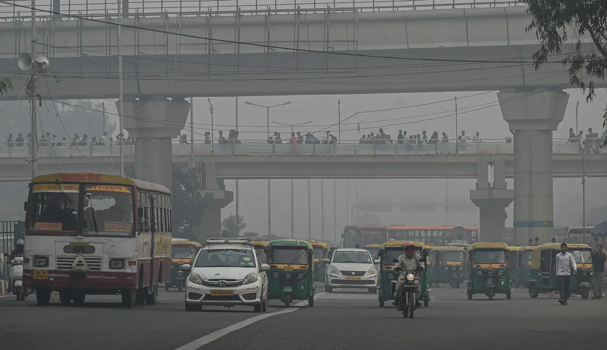 Kendaraan berjalan di sepanjang jalan di tengah kondisi kabut asap tebal di New Delhi (15/11/2021). India memutuskan untuk menutup sekolah di New Delhi selama sepekan dan berencana menerapkan lockdown untuk melindungi warganya. (AFP/Money Sharma)