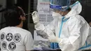 Seorang petugas kesehatan melakukan tes COVID-19 pada seorang pria di sebuah rumah sakit di Manila, Filipina, Senin (26/4/2021). Infeksi virus corona COVID-19 di Filipina melonjak melewati 1 juta pada hari Senin dalam tonggak suram terbaru. (AP Photo/Aaron Favila)