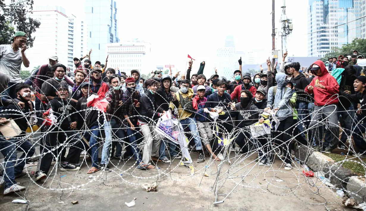 Pengunjuk rasa berupaya menerobos barikade polisi di kawasan Patung Kuda, Jakarta Pusat, Selasa (13/10/2020). Bentrokan antara massa aksi menolak UU Cipta Kerja dan kepolisian pecah. (Liputan6.com/Faizal Fanani)