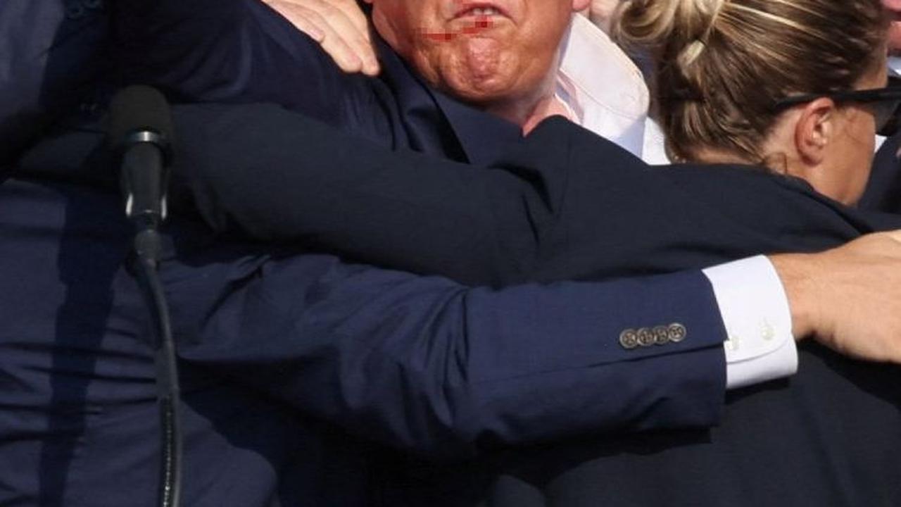 Dengan darah berceceran di wajah dan telinganya, Donald Trump mengangkat kepalan tangan. "Lawan!" katanya. "Lawan!"  Foto: Reuters