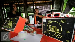 Sejumlah mahasiswa dari komunitas penjelajah langit sedang membuat peralatan kotak lubang jarum yang akan di gunakan untuk mengamati gerhana matahari di taman Pintar Yogyakarta, (2/3). (Liputan6.com/Boy Harjanto)