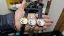 Seorang penjual menunjukan jam tangan yang bergambar mantan Presiden Irak, Saddam Hussein di Baghdad, Irak (28/12). Saddam Hussein adalah Presiden Irak yang menjabat sejak periode 16 Juli 1979 hingga 9 April 2003. (AFP/Sabah Arar)