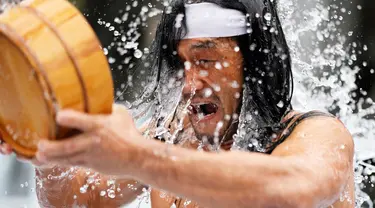 Seorang jemaat yang setengah telanjang menyiram dirinya dengan air dingin saat ritual ketahanan dingin di Kuil Shinto Kanda Myojin, Tokyo, Jepang, Sabtu (14/1/2023). Dalam ritual yang berlangsung selama dua hari dan menjadi bagian dari festival Shinto itu peserta menuangkan air dingin ke tubuh karena diyakini dapat menyucikan jiwa mereka. (AP Photo/Hiro Komae)