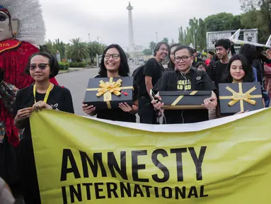 Aktivis yang tergabung dalam Amnesty Internasional Indonesia menggelar aksi di depan Istana Negara, Jakarta, Selasa (10/12/2019). Aksi tersebut digelar untuk memperingati Hari HAM Sedunia 2019. (Liputan6.com/Faizal Fanani)