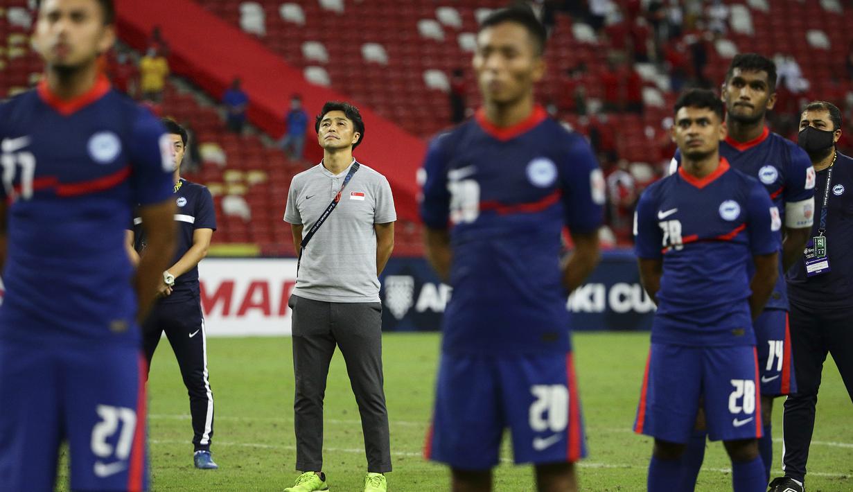 Pelatih Singapura, Tatsuma Yoshida bersama para pemain berdiri mendengarkan Lagu Kebangsaan Singapura usai dikalahkan Indonesia. (AP/Suhaimi Abdullah)