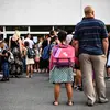 Anak-anak dan orang tua menunggu guru memanggil nama mereka pada hari pertama sekolah di sekolah dasar Condorcet di Lormont, di pinggiran Bordeaux, barat daya Prancis, Senin (4/9/2023). (Christophe ARCHAMBAULT / AFP)