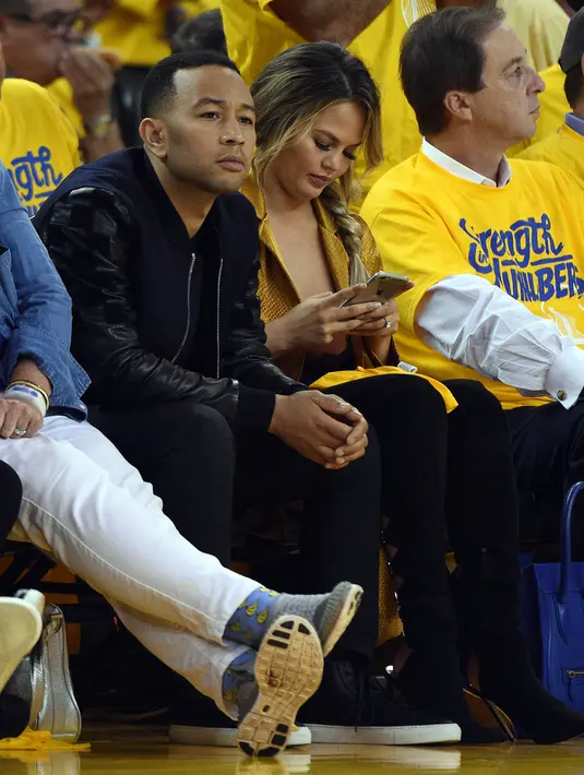 Penyanyi, John Legend bersama sang istri Chrissy Teigan saat menyaksikan pertandingan final NBA 2016 antara Golden State Warriors dan Cleveland Cavaliers di Oracle Arena, California, USA (2/6/2016). (Kyle Terada-USA TODAY Sports)