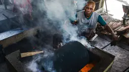 Pekerja memanggang biji kopi melalui metode tradisional di sebuah pabrik di Banda Aceh, Aceh, Rabu (3/3). (CHAIDEER MAHYUDDIN/AFP)
