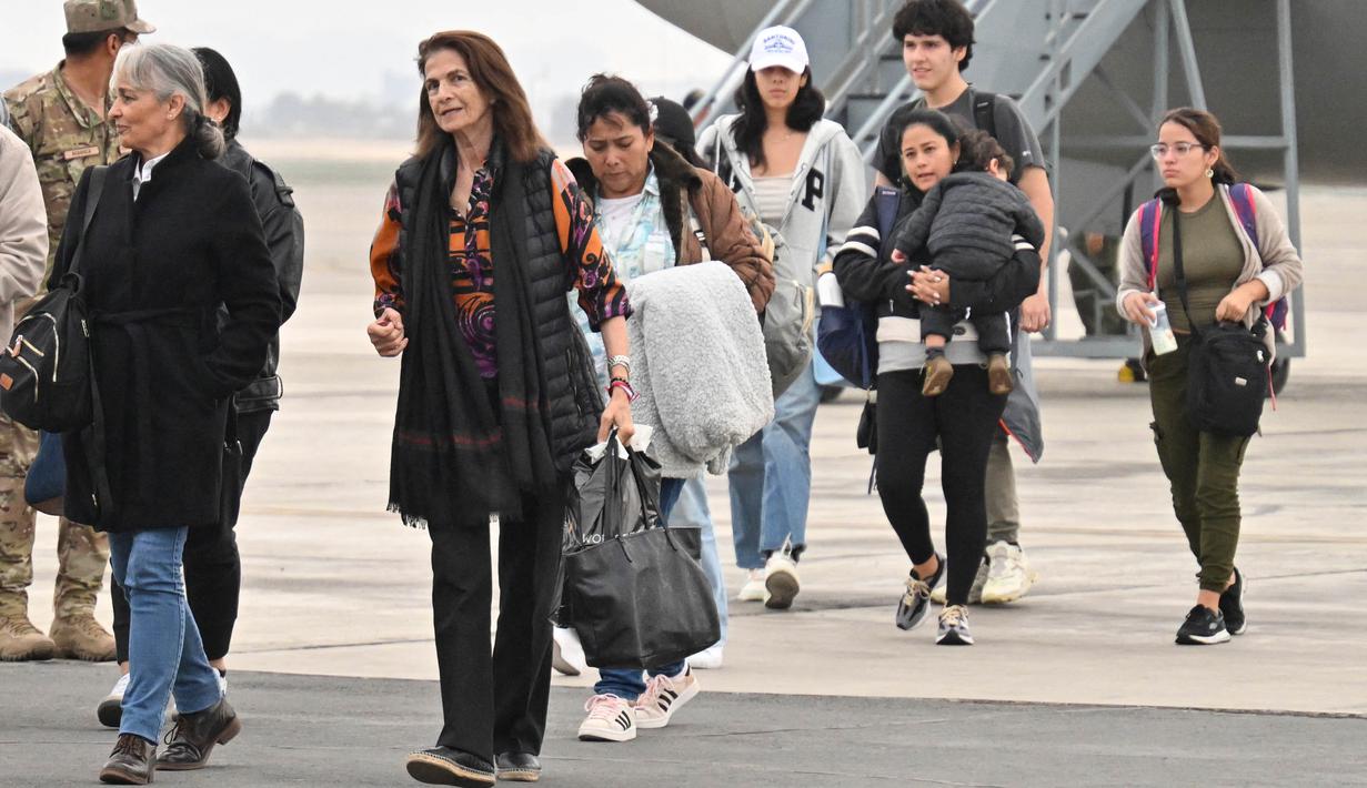 Warga negara Peru yang dipulangkan dari konflik antara Israel dan Hamas, turun dari pesawat kepresidenan Boeing 737 setibanya di pangkalan Angkatan Udara di Callao, sebuah provinsi yang berdekatan dengan Lima, pada 15 Oktober 2023. (Cris BOURONCLE/AFP)