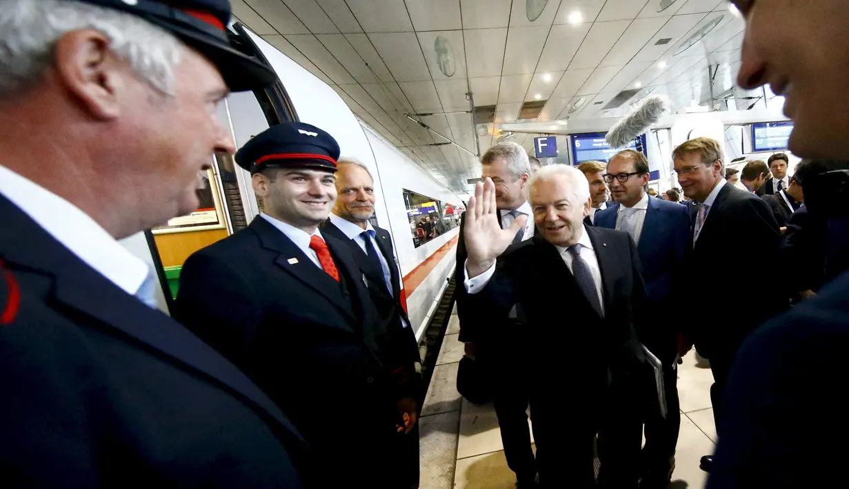Ruediger Grube (tengah), CEO dari kereta api Jerman Deutsche Bahn AG, menyapa staf gabungan dari kereta api sebelum naik perdana kereta ICE kecepatan tinggi di Stasiun Kereta Api, Jerman, Kamis (23/7). (REUTERS/Kai Pfaffenbach) 