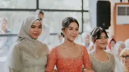 Setelah Raka tiba di tempat acara lamaran, Adinda Thomas pun muncul dengan wajah sumringah dengan kebaya modern warna peach sangat mewah dengan sentuhan payet dan swarovski. Untuk polesan makeup-nya, pemain film KKN Desa Penari itu memilih warna natural dan nude. Kalung simpel yang dipakainya mendukung penampilannya jadi makin cantik dan elegan. (Liputan6.com/IG/@adindathomas)