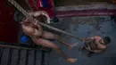 Pegulat tradisional India berlatih panjat tali selama latihan harian mereka di semacam asrama gulat di Sabzi Mandi, New Delhi (20/11). Walau tergerus zaman, olahraga tradisional ini terus di lestarikan sebagai bagian dari budaya India.(AP Photo/Dar Yasin)