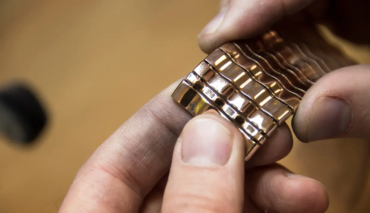 Pekerja Comite Franceclat menyelesaikan pembuatan gelang emas 'Dunes' yang dibuat dengan mesin cetak 3D di Besancon, Prancis timur, 11 Oktober 2017. Mesin cetak 3D kini mulai merambah ke dunia desain perhiasan. (AFP FOTO / SEBASTIEN BOZON)
