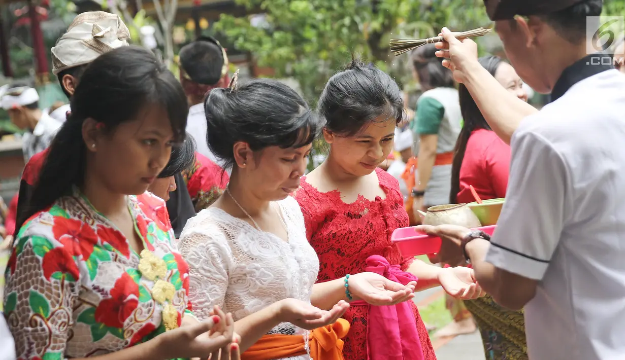 Pemuka agama Hindu memberikan air suci untuk sembahyang di Pura Aditya Jaya, Jakarta, Sabtu (17/3). Nyepi dirayakan dengan melakukan kegiatan keagamaan di pura. (Liputan6.com/Herman Zakharia)