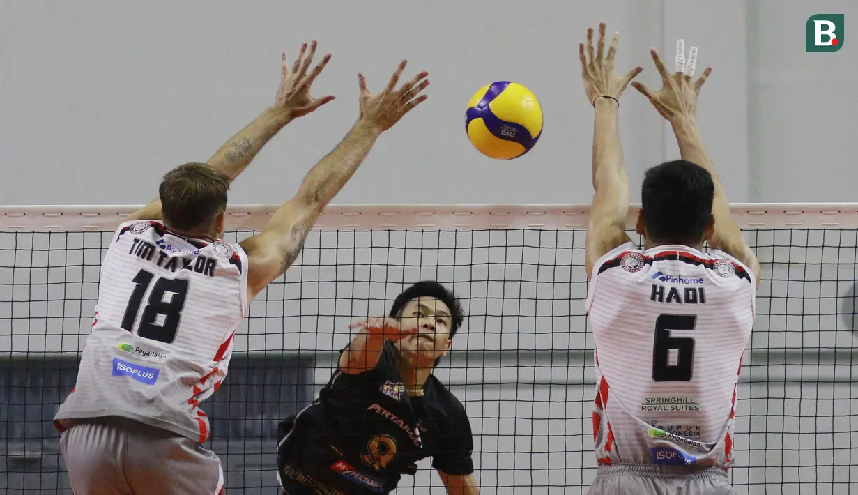 Pemain Surabaya Bhayangkara Samator, Tim Taylor (kiri) dan Hadi berusaha memblok bola smes pemain Jakarta Pertamina Pertamax, Farhan pada laga PLN Mobile Proliga 2022 di Padepokan Voli Jenderal Polisi Kunarto, Sentul, Sabtu (29/1/2022). (Bola.com/M Iqbal Ichsan)