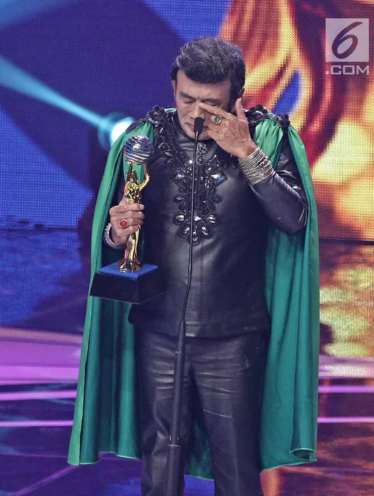 Penyanyi dangdut  Rhoma Irama menerima piala untuk kategori Lifetime Achievement dalam ajang Indonesian Dangdut Awards 2017 di Studio 6 EMTEK CITY, Jakarta, Jumat (13/10). (Liputan6.com/Herman Zakharia)