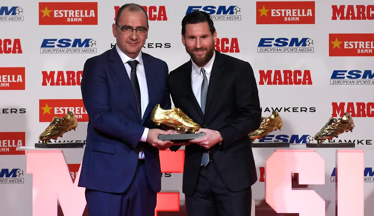 Megabintang Barcelona, Lionel Messi berpose dengan Direktur jurnal olahraga Marca, Juan Ignacio Gallardo saat menerima trofi Golden Boot alias Sepatu Emas Eropa dalam sebuah acara di Antiga Fabrica Estrella Damm, Selasa (18/12). (LLUIS GENE/AFP)