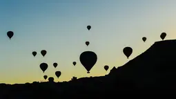 Pemandangan siluet balon udara panas yang terbang di atas Nevsehir di wilayah Cappadocia, Turki (5/9). Cappadocia adalah tempat yang unik yang tujuan utama wisatawan yang datang ke Turki. (AFP Photo/Yasin Akgul)