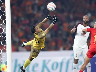 Kiper PSM Makassar, Reza Arya Pratama berhasil menepis sundulan pemain Persija Jakarta, Hanif Sjahbandi pada laga pekan pertama BRI Liga 1 2023/2024 antara Persija Jakarta menghadapi PSM Makassar di Stadion Utama Gelora Bung Karno (SUGBK), Senayan, Jakarta, Senin (3/7/2023). (Bola.com/M Iqbal Ichsan)