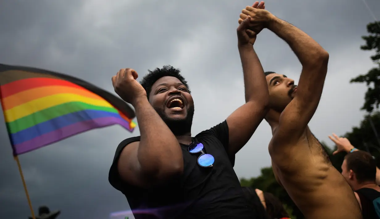 Dua pria menari saat mengikuti parade ‘Gay Pride’ di Berlin, Jerman, Sabtu (22/7). Pendukung gay dan lesbian berpesta setelah Parlemen Jerman melegalkan pernikahan sesama jenis. (AP/Markus Schreiber)