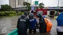 Petugas dari Suku Dinas Tata Air memasang mesin pompa untuk menyedot air banjir yang merendam Jalan Gunung Sahari, Jakarta, Selasa (21/2). Hujan yang mengguyur sejak Selasa dinihari membuat sebagian wilayah di Jakarta banjir. (Liputan6.com/Faizal Fanani)