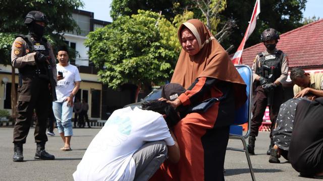 Anggota pesilat Tuban sungkem ke orang tua usai diamankan karena konvoi hendak tawuran. (Adirin/Liputan6.com)
