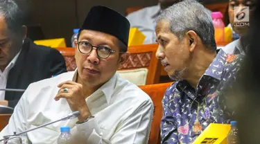 Menteri Agama Lukman Hakim Saifuddin berbincang dengan Kepala BPKH Anggito Abimanyu saat mengikuti Rapat Dengar Pendapat (RDP) dengan Komisi VIII DPR RI di Kompleks Parlemen, Senayan, Jakarta, Selasa (23/4). RDP membahas penambahan jumlah kuota haji tahun 1440 H/ 2019 M. (Liputan6.com/Johan Tallo)