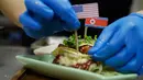 Seorang koki menghias makanan taco bernama El Trumpo dan Rocket Man di sebuah restoran di Singapura, 7 Juni 2018. Makanan itu memanfaatkan momentum pertemuan Donald Trump dan Pemimpin Korea Utara Kim Jong-un di Singapura 12 Juni nanti. (AP/Wong Maye-E)